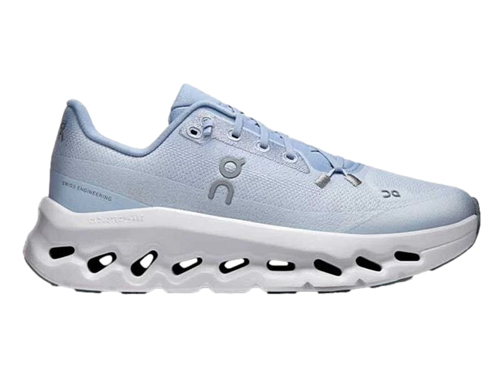 Tenis deportivos On Cloud color azul claro con suela blanca ancha y diseño moderno.