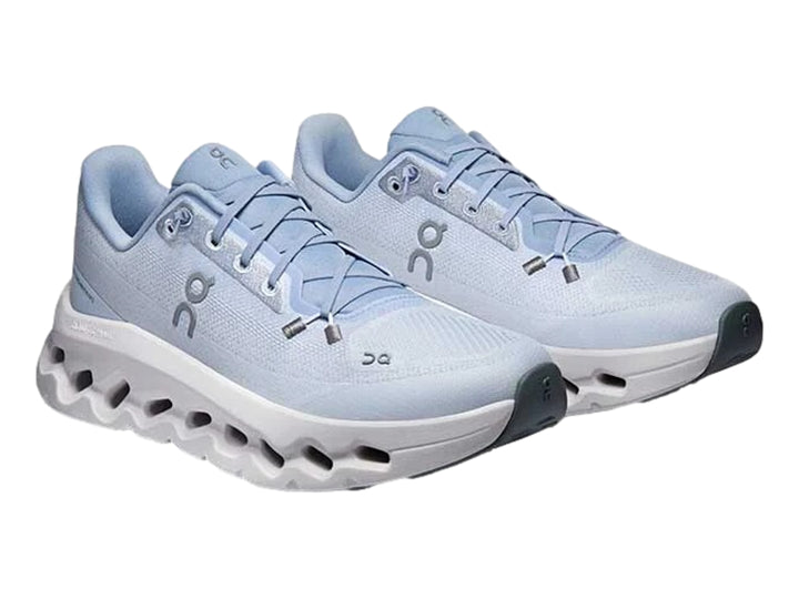 Tenis deportivos On Cloud color azul claro con suela blanca ancha y diseño moderno.