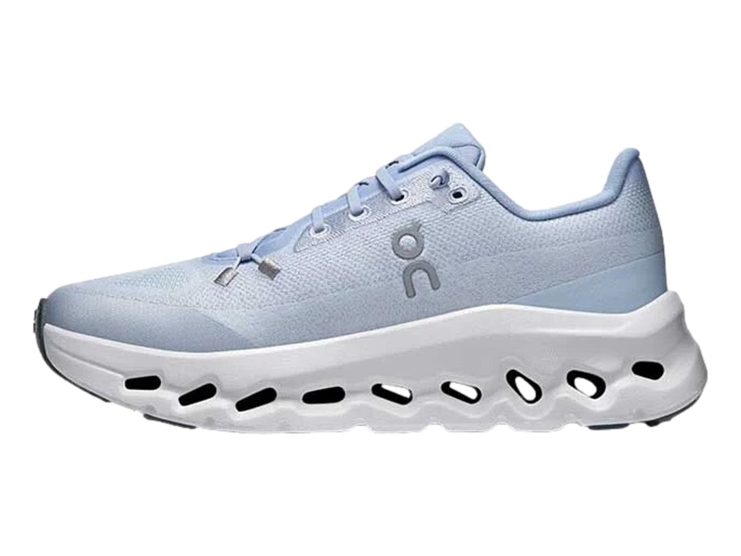Tenis deportivos On Cloud color azul claro con suela blanca ancha y diseño moderno.