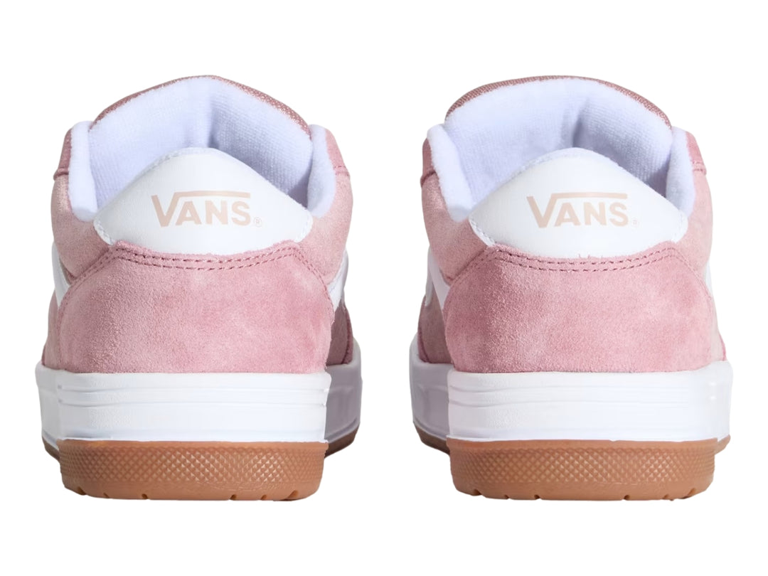 Tenis Vans color rosa con franja lateral blanca, suela intermedia blanca y suela exterior color caramelo.
