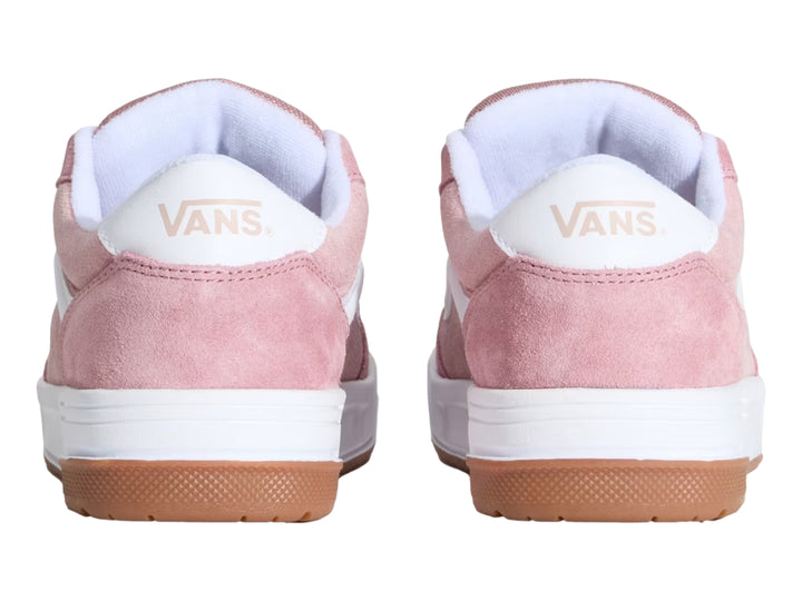 Tenis Vans color rosa con franja lateral blanca, suela intermedia blanca y suela exterior color caramelo.