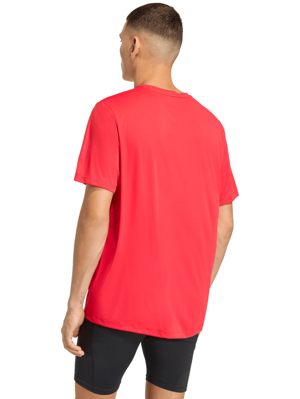 Hombre vistiendo playera deportiva roja de manga corta marca Adidas.
