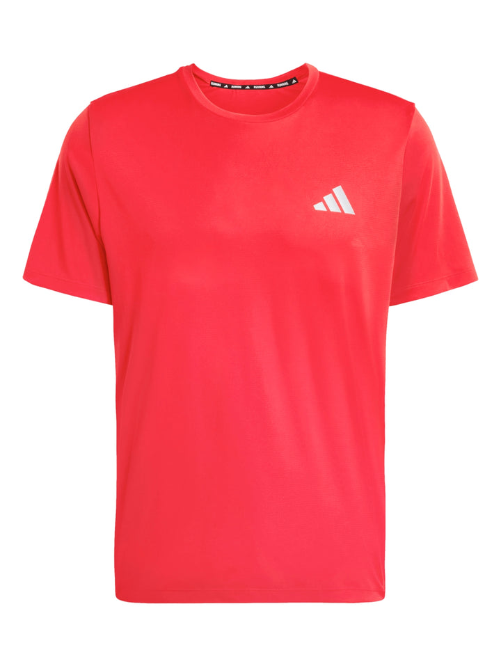 Hombre vistiendo playera deportiva roja de manga corta marca Adidas.