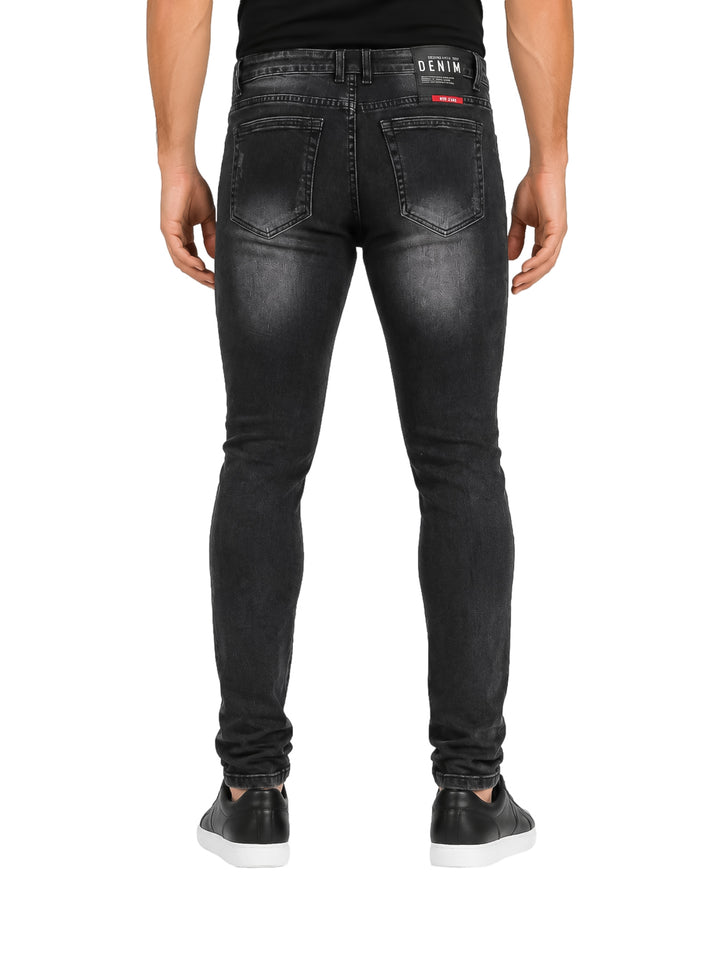 Jeans color negro para hombre con efecto desgastado y corte ajustado.