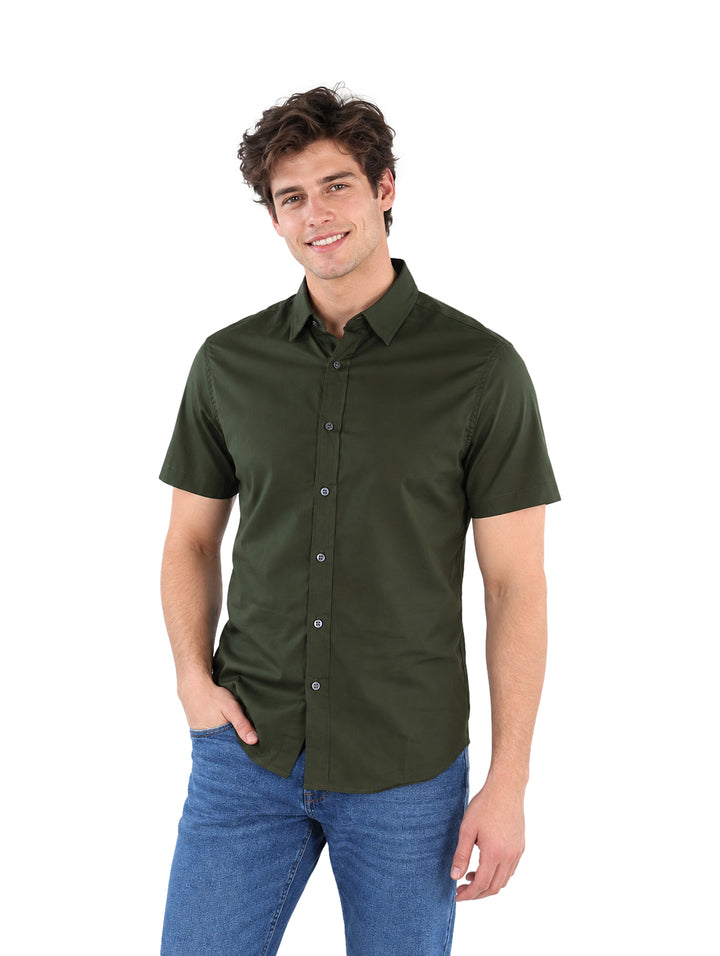 Hombre vistiendo una camisa de manga corta color verde militar y pantalones azules.
