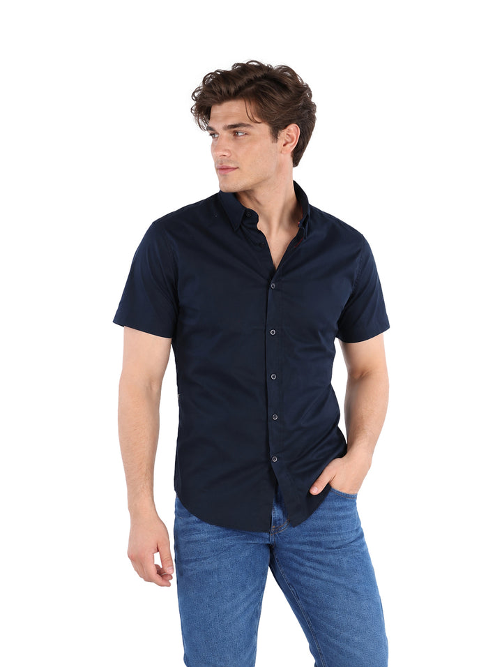 Hombre vistiendo una camisa negra de manga corta y pantalones vaqueros azules.
