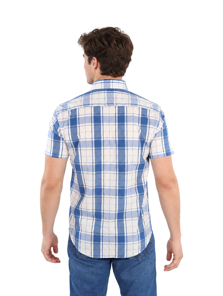 Hombre vistiendo camisa de manga corta con estampado de cuadros en color azul y blanco.