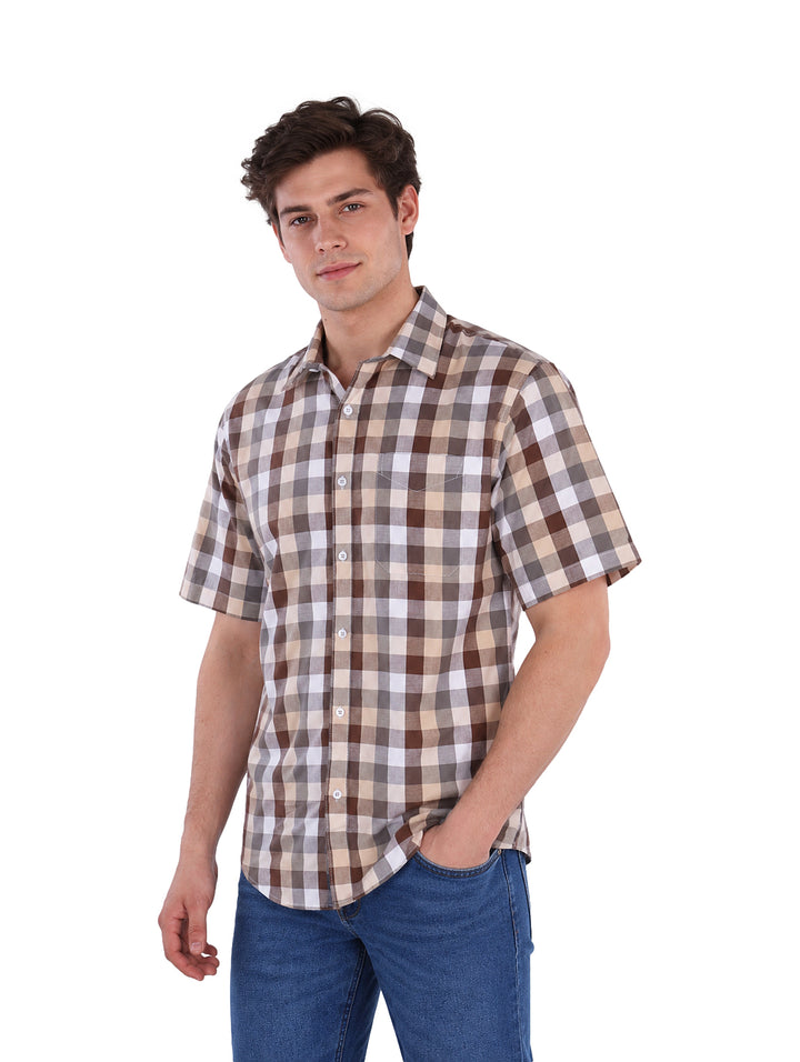 Hombre vistiendo camisa de manga corta con estampado de cuadros en colores beige, café y blanco.