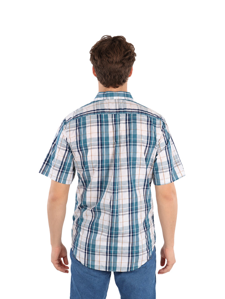 Hombre vistiendo camisa de manga corta con estampado de cuadros en colores teal, marino y blanco.