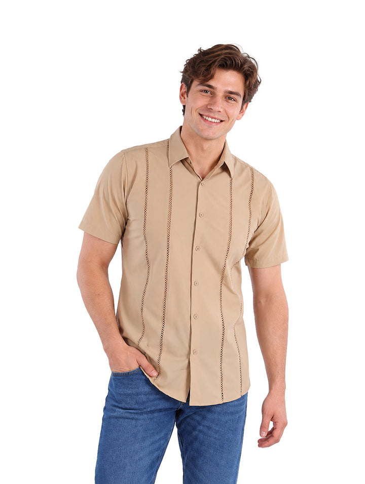 Hombre vistiendo una camisa de manga corta color kaki con detalles de costuras verticales y jeans azules.