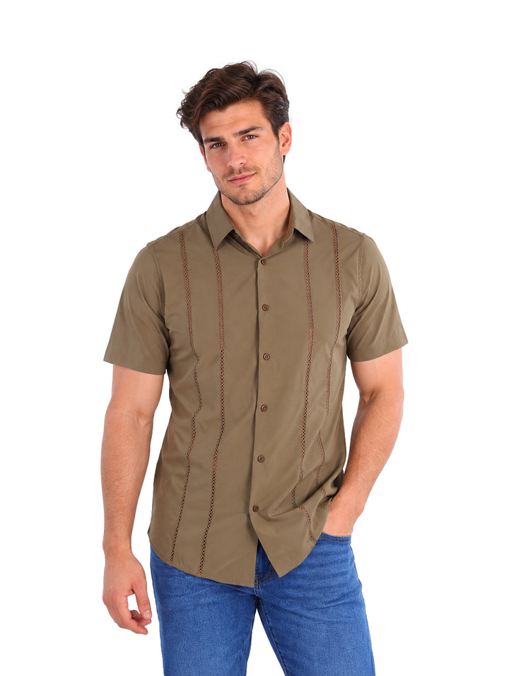 Hombre vistiendo una camisa de manga corta color oliva con detalles de costuras verticales.