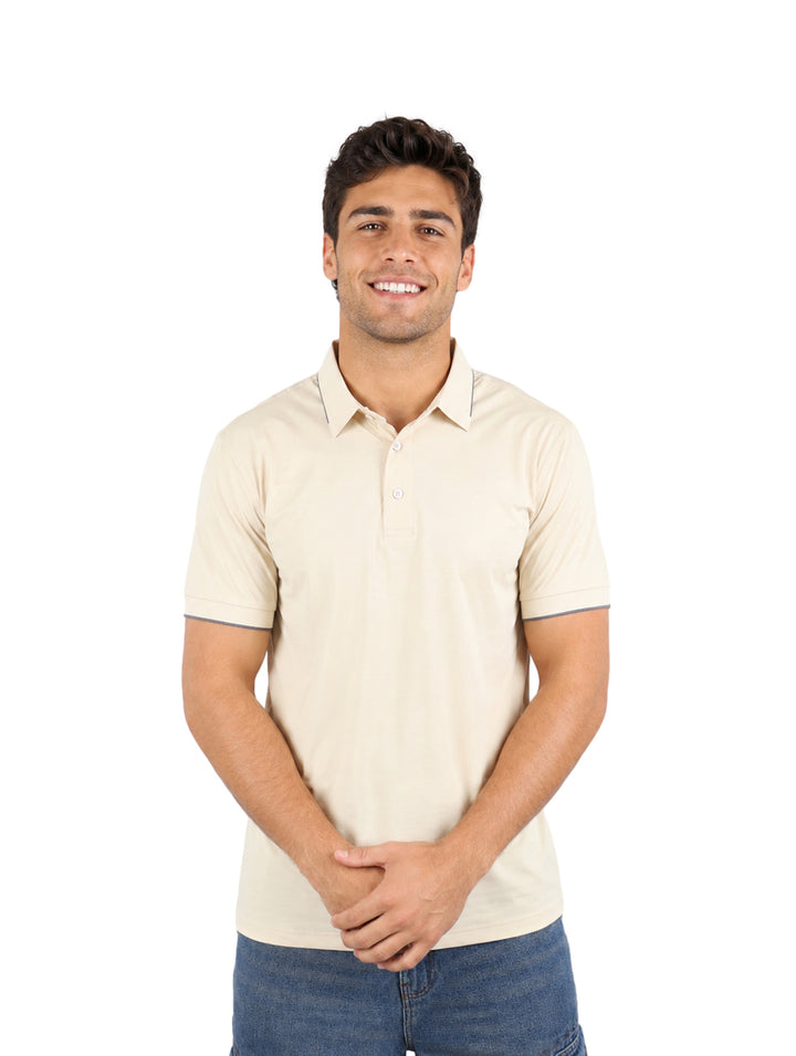 Hombre vistiendo una playera tipo polo color beige de manga corta.