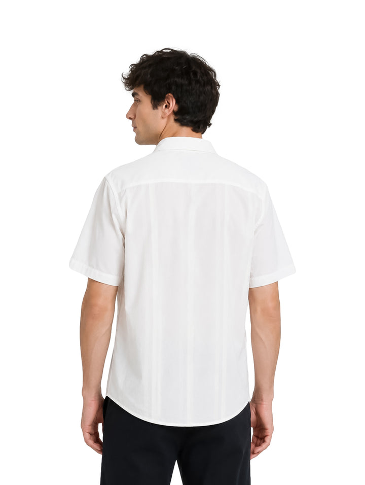 Hombre vistiendo camisa blanca de manga corta con detalles verticales y cuello, estilo elegante.