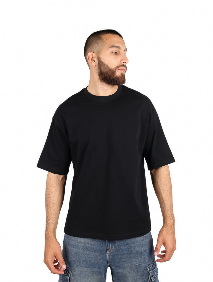 Hombre vistiendo una playera color negro de manga corta y cuello redondo.