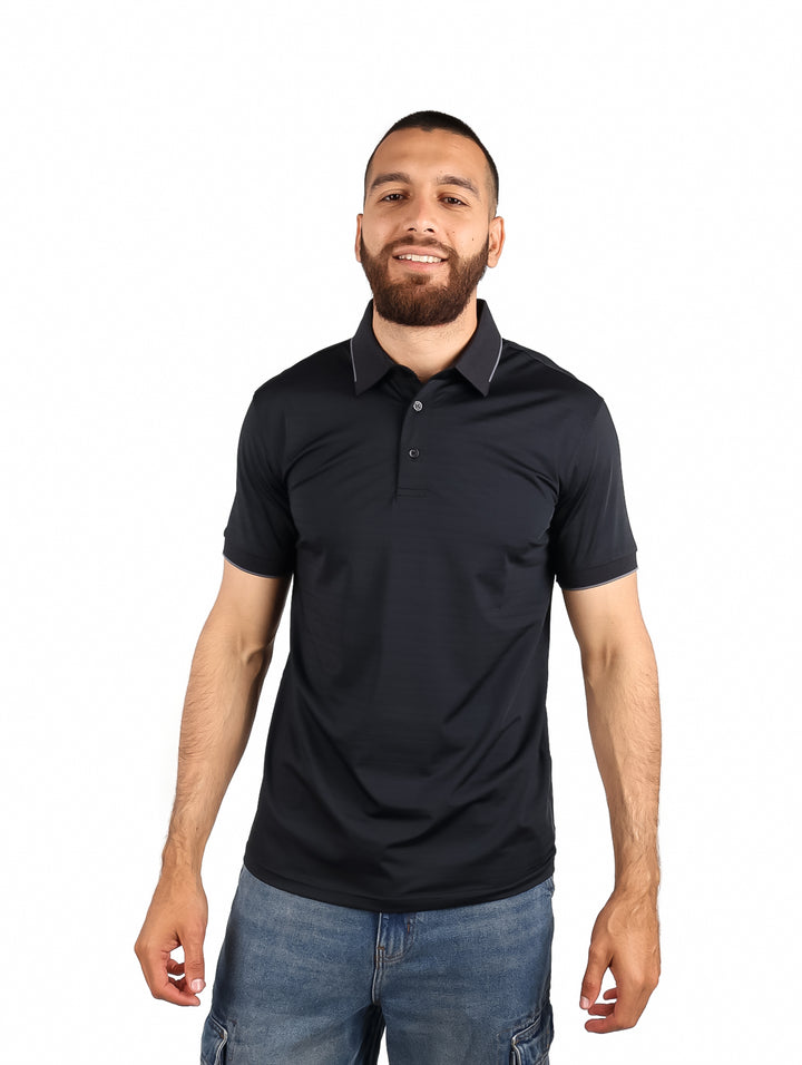 Hombre vistiendo una playera polo color negro de manga corta con detalles blancos en el cuello.