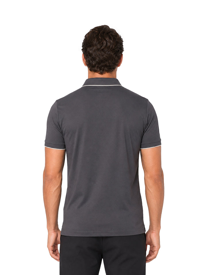 Hombre vistiendo playera polo color charcoal con ribetes blancos en el cuello y mangas.