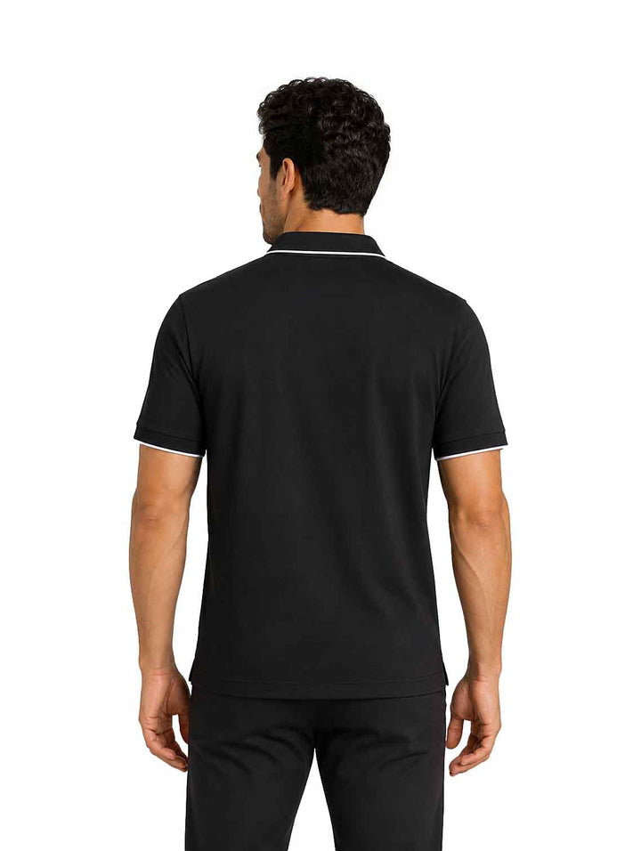 Hombre vistiendo playera polo color negro con detalles blancos en cuello y mangas.