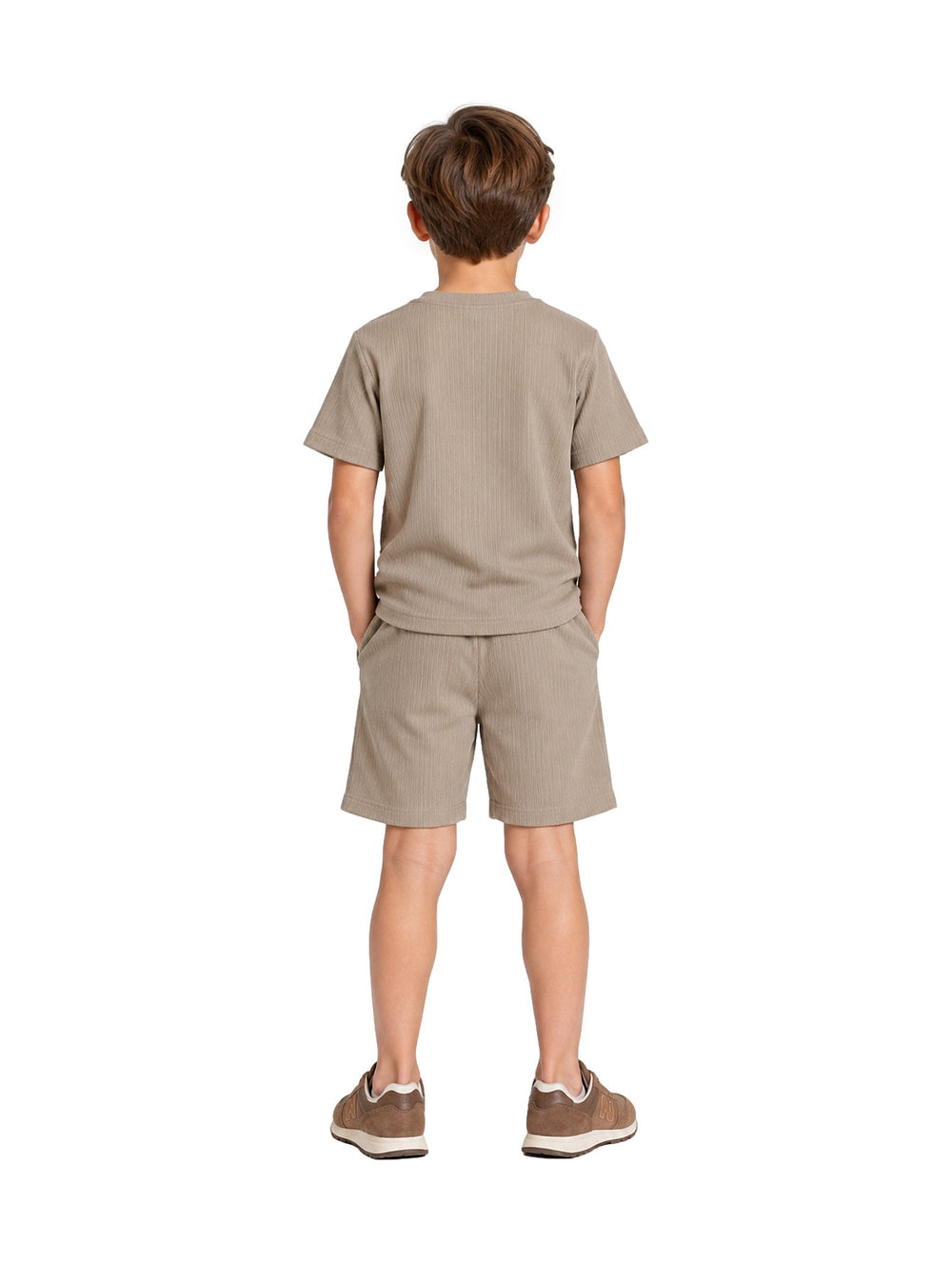 Niño vistiendo un conjunto de camiseta y short en color verde claro con textura acanalada y tenis marrones.