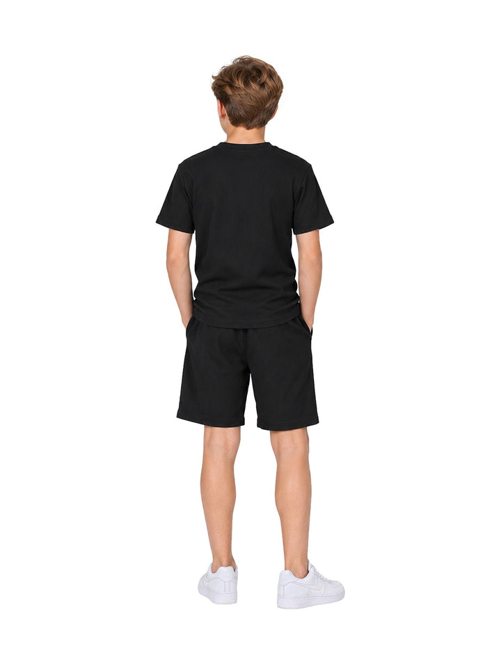 Niño vistiendo conjunto Atok negro compuesto por camiseta de manga corta y shorts a juego.