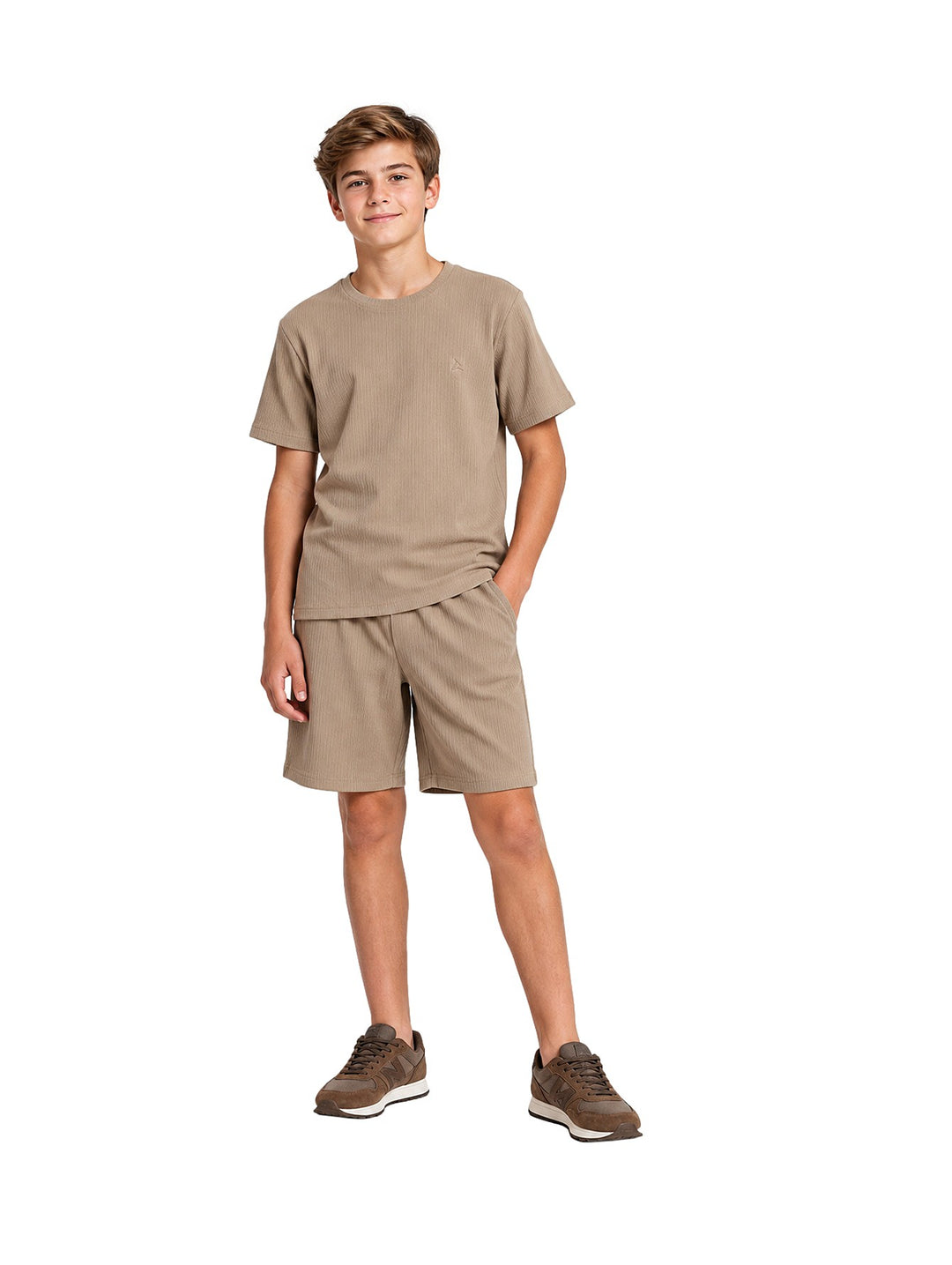 Niño vistiendo un conjunto casual de camiseta y shorts color khaki con tenis marrones.