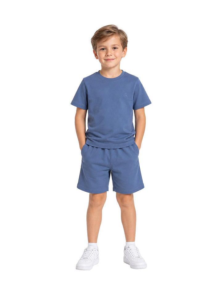 Niño vistiendo conjunto Atok azul denim compuesto por camiseta de manga corta y shorts a juego.
