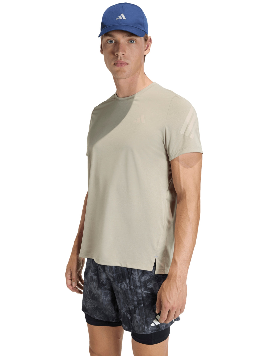 Hombre vistiendo camiseta deportiva Adidas color gris claro y shorts oscuros.