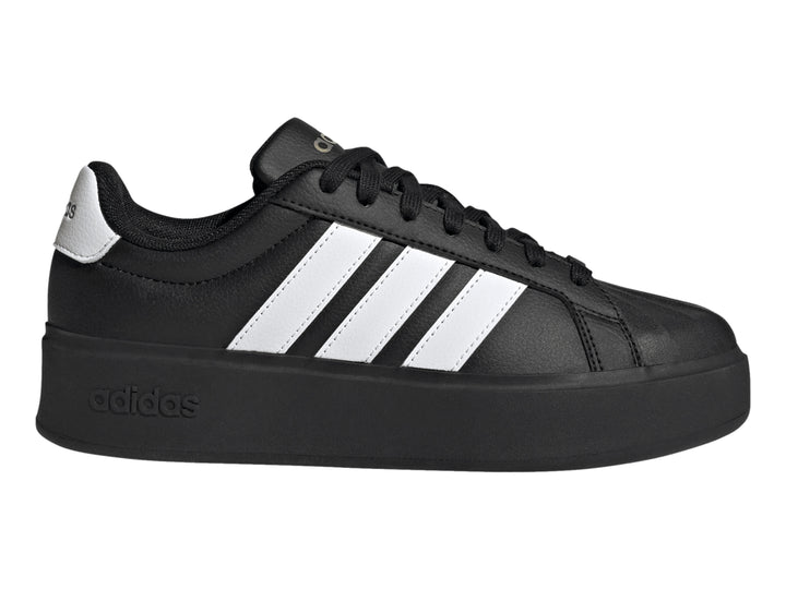 Tenis Adidas negros con franjas blancas laterales y suela de plataforma gruesa.