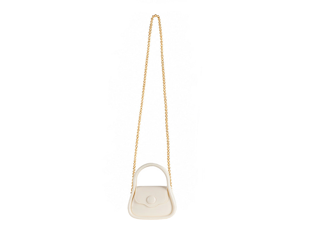 Bolsa de mano color latte con asa circular y acabado brillante.