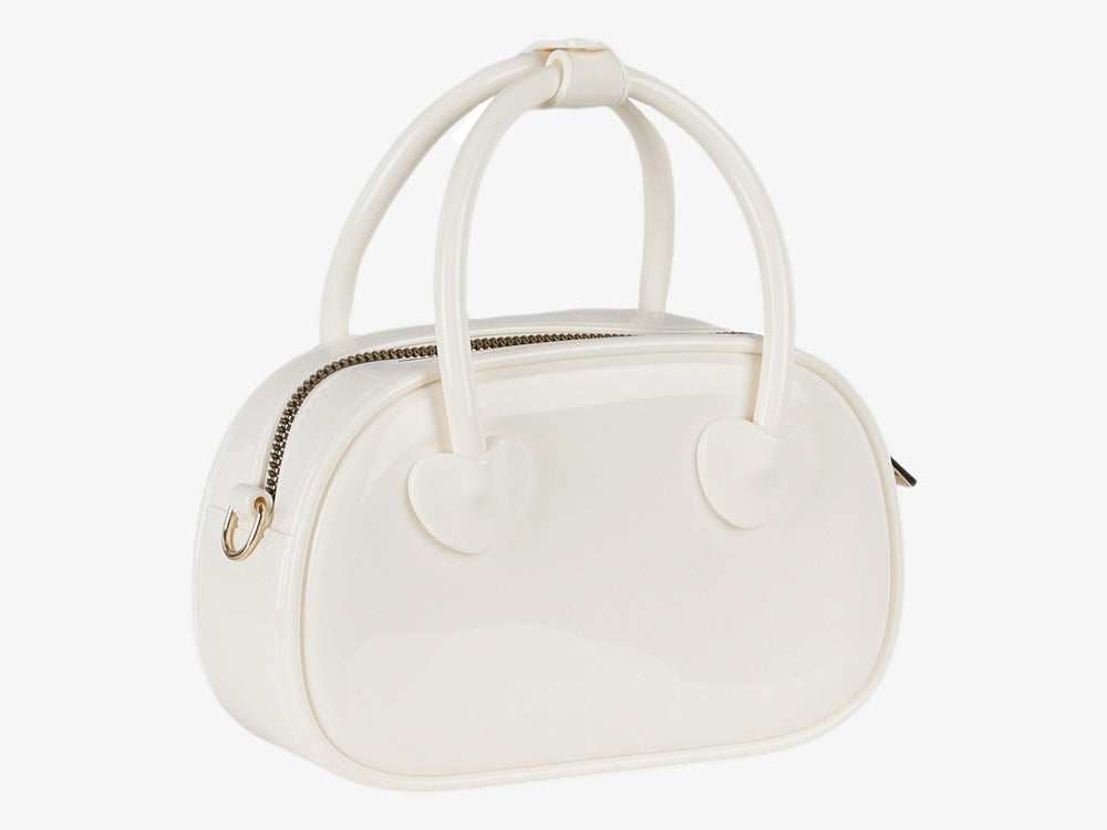 Bolsa de plástico color latte con detalles de corazones y asa superior.