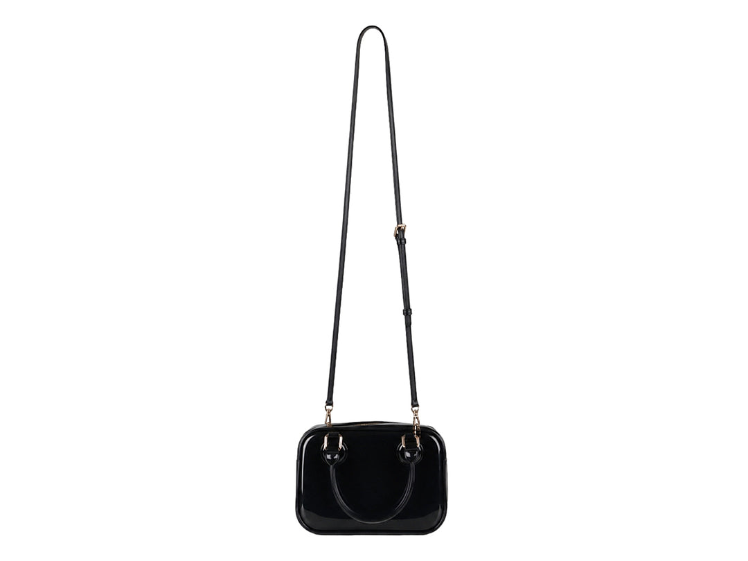 Bolsa de plástico color negro brillante con asa superior y detalles en color dorado.