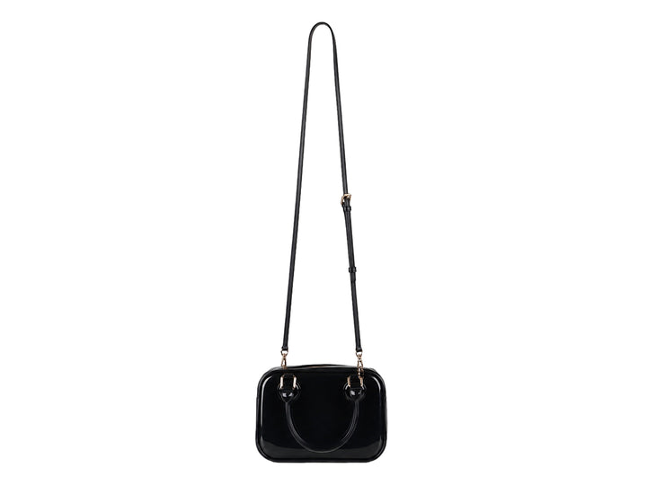Bolsa de plástico color negro brillante con asa superior y detalles en color dorado.