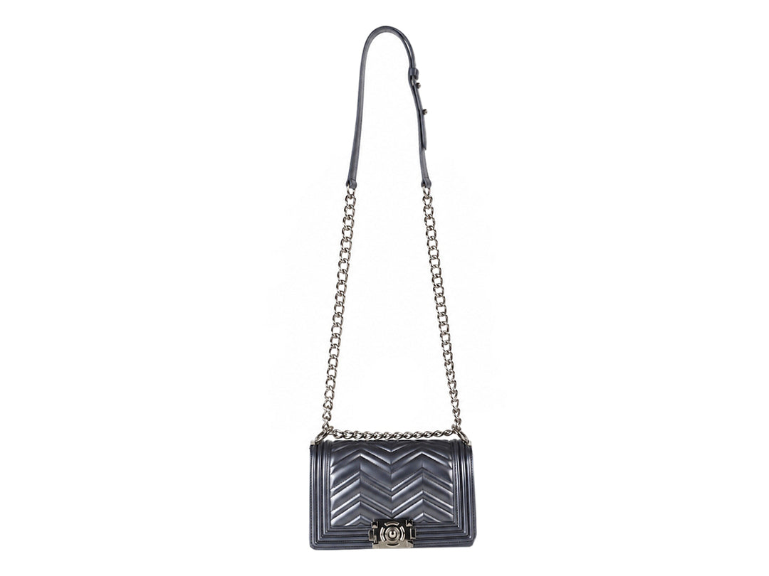 Bolsa de hombro color plata con correa de cadena y diseño acolchado en chevron.