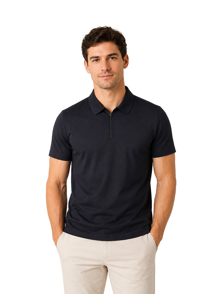 Hombre vistiendo playera polo color negro con cierre frontal y pantalones beige.