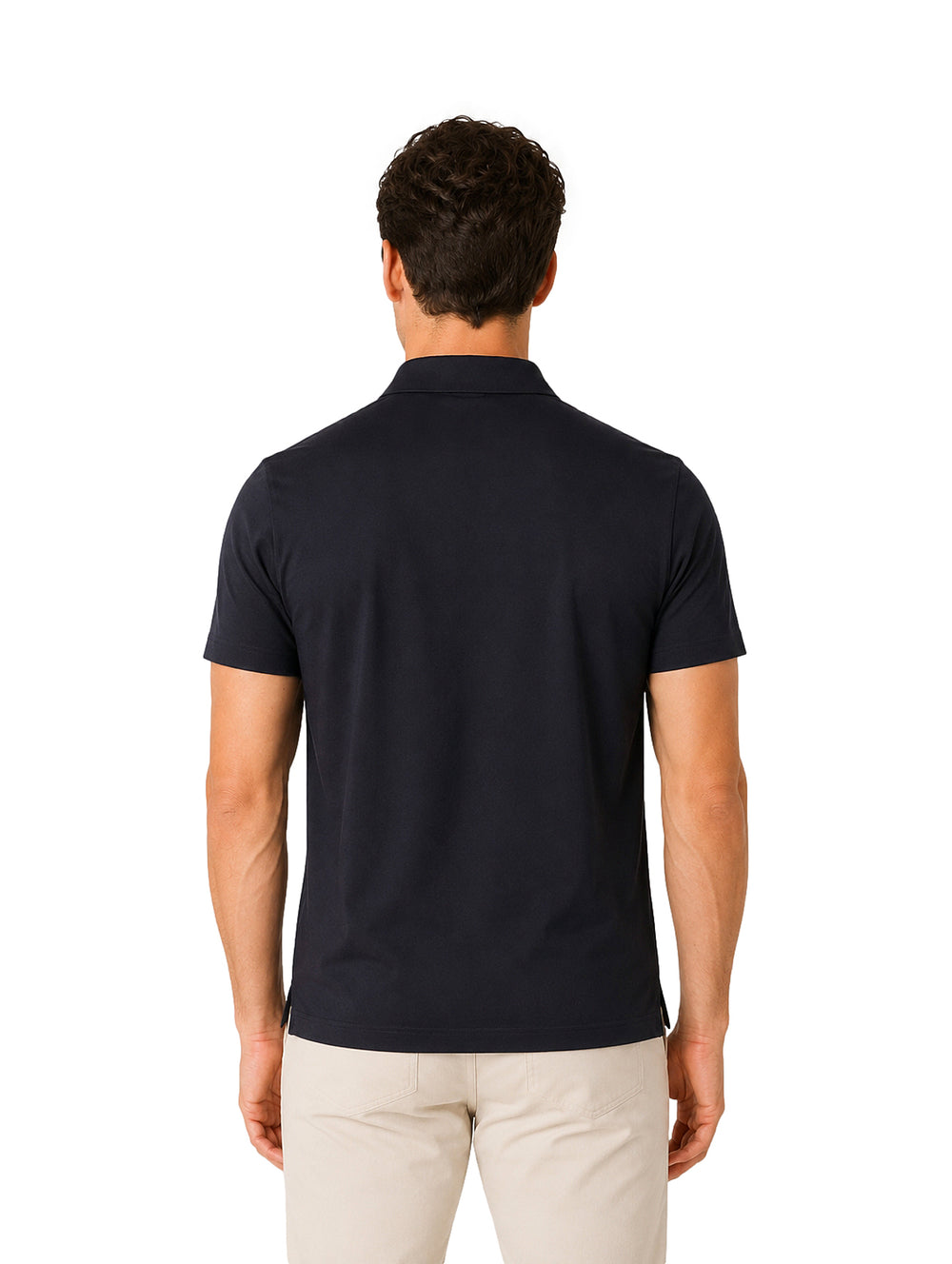 Hombre vistiendo playera polo color negro con cierre frontal y pantalones beige.