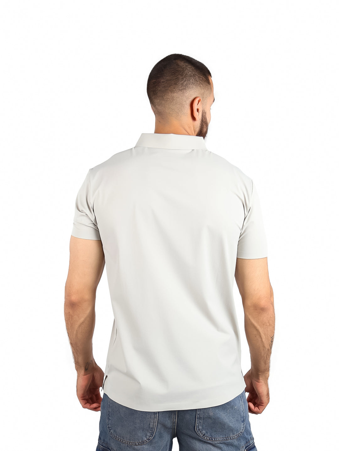 Hombre vistiendo playera polo color gris claro con cierre vertical y cuello