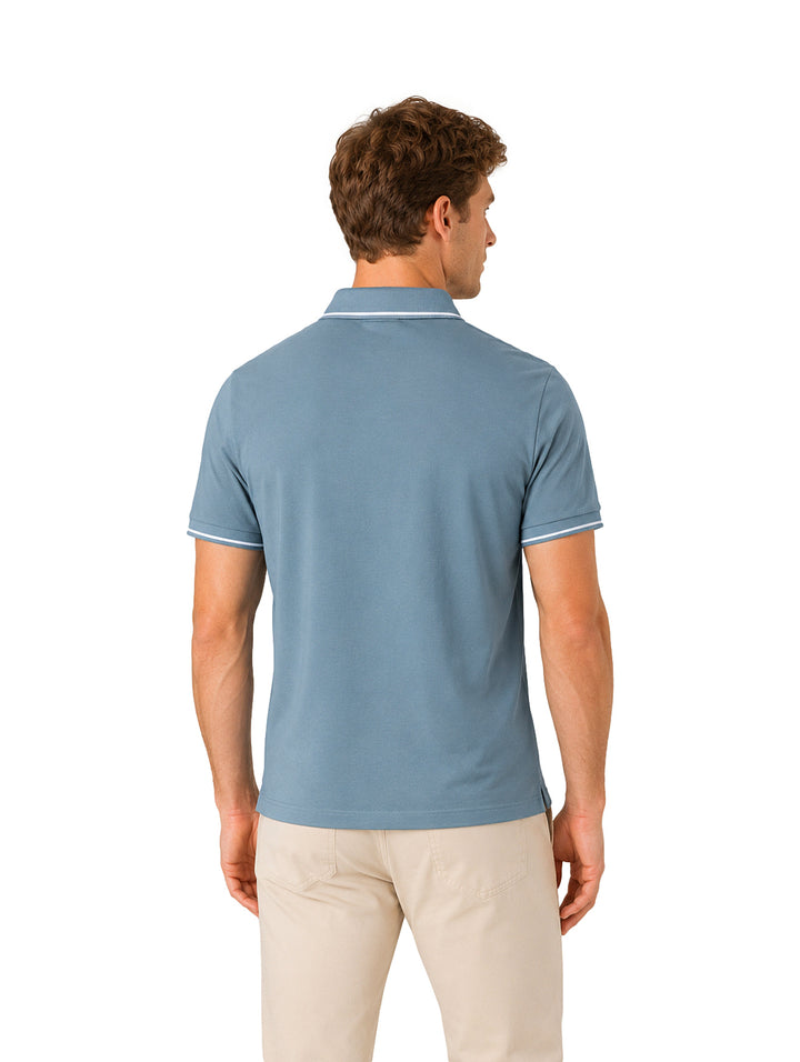 Hombre vistiendo playera polo color azul con detalles blancos en cuello y mangas.