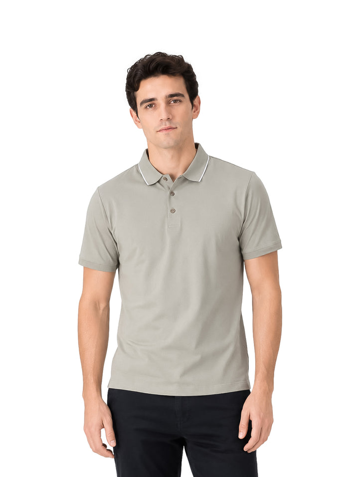 Hombre vistiendo playera polo color olive de manga corta con detalle blanco en el cuello.