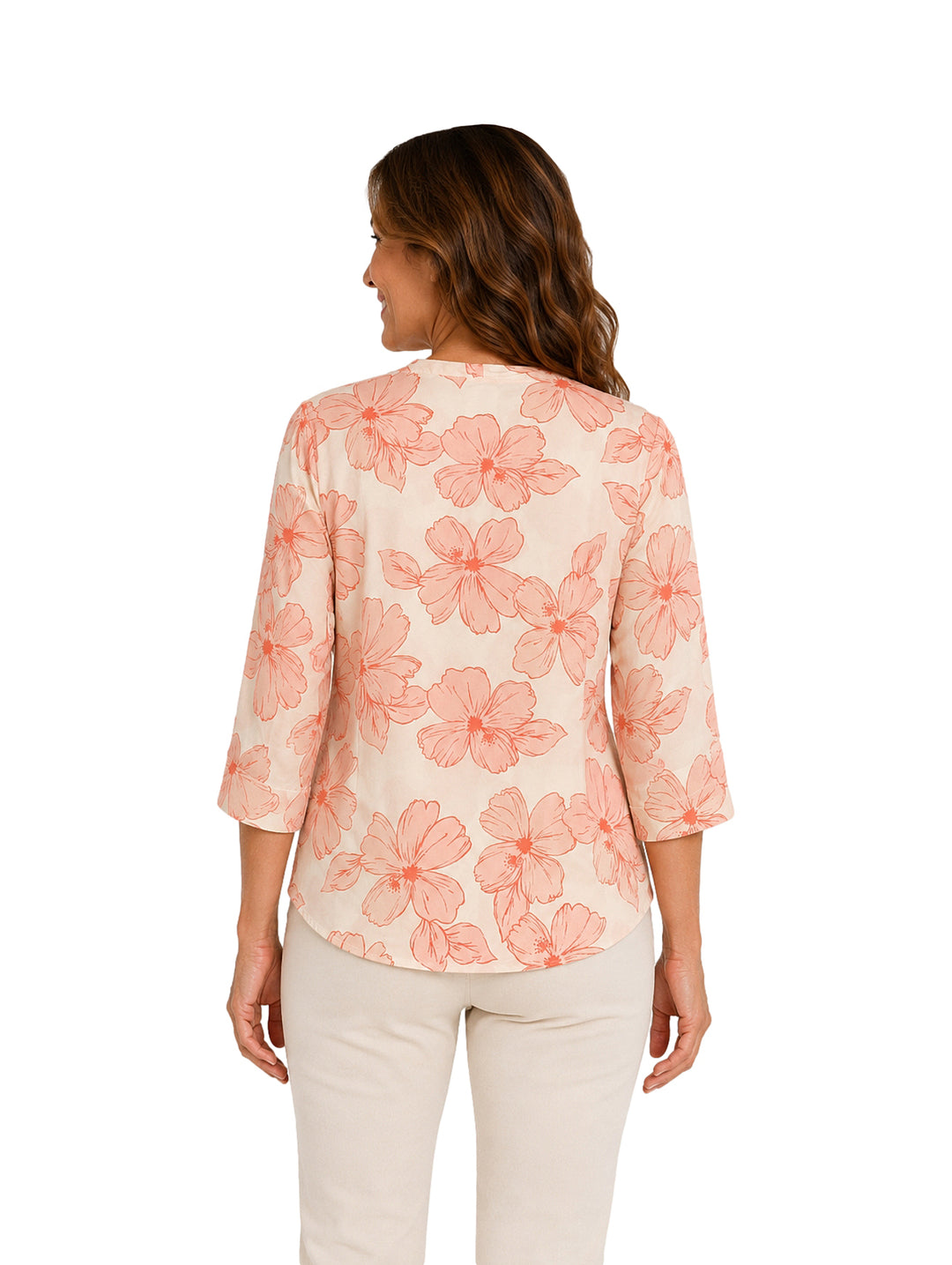 Mujer vistiendo blusa color coral y crema con estampado floral y collar circular.