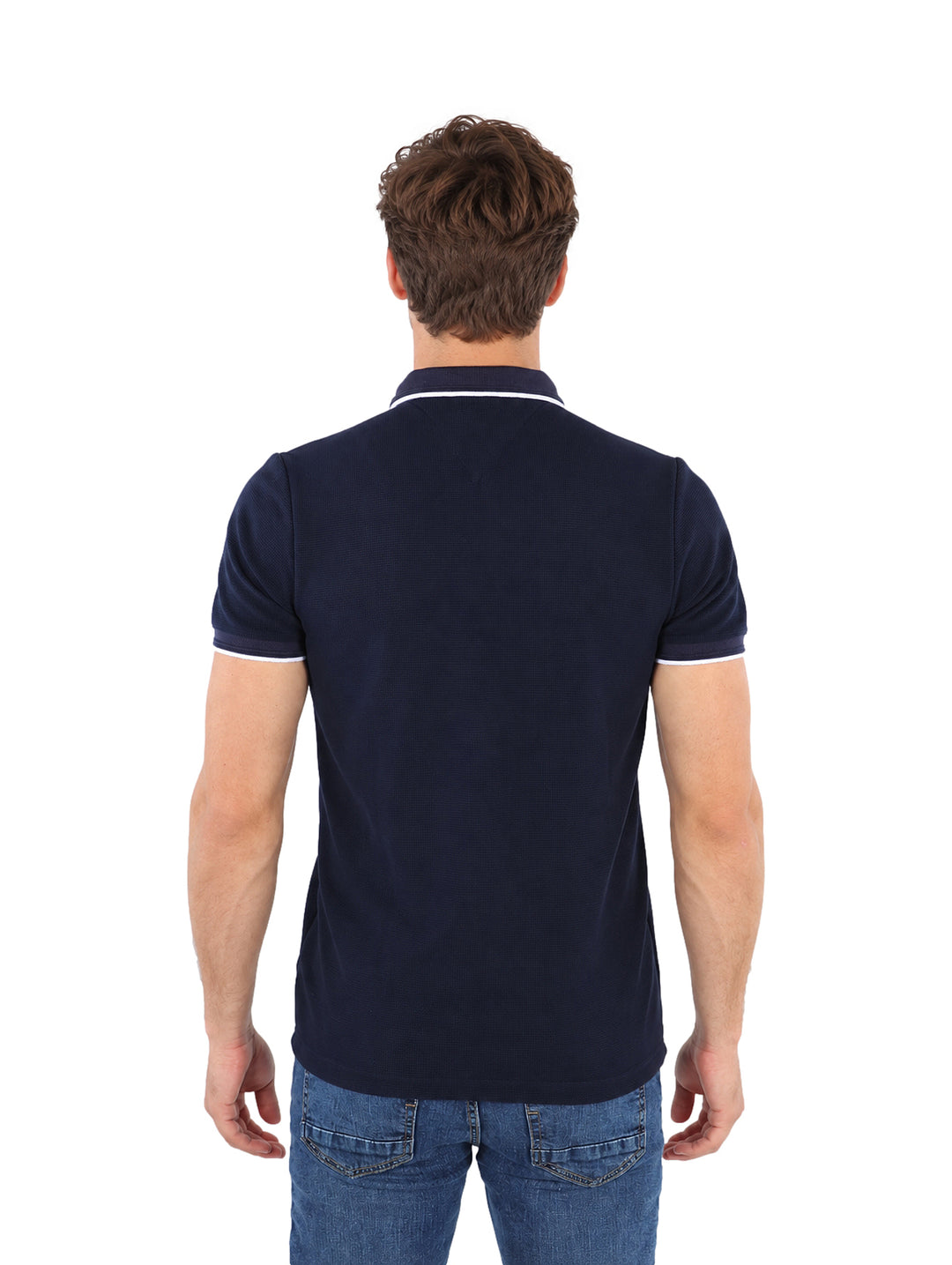 Hombre vistiendo playera polo color marino con detalles blancos en el cuello y mangas.