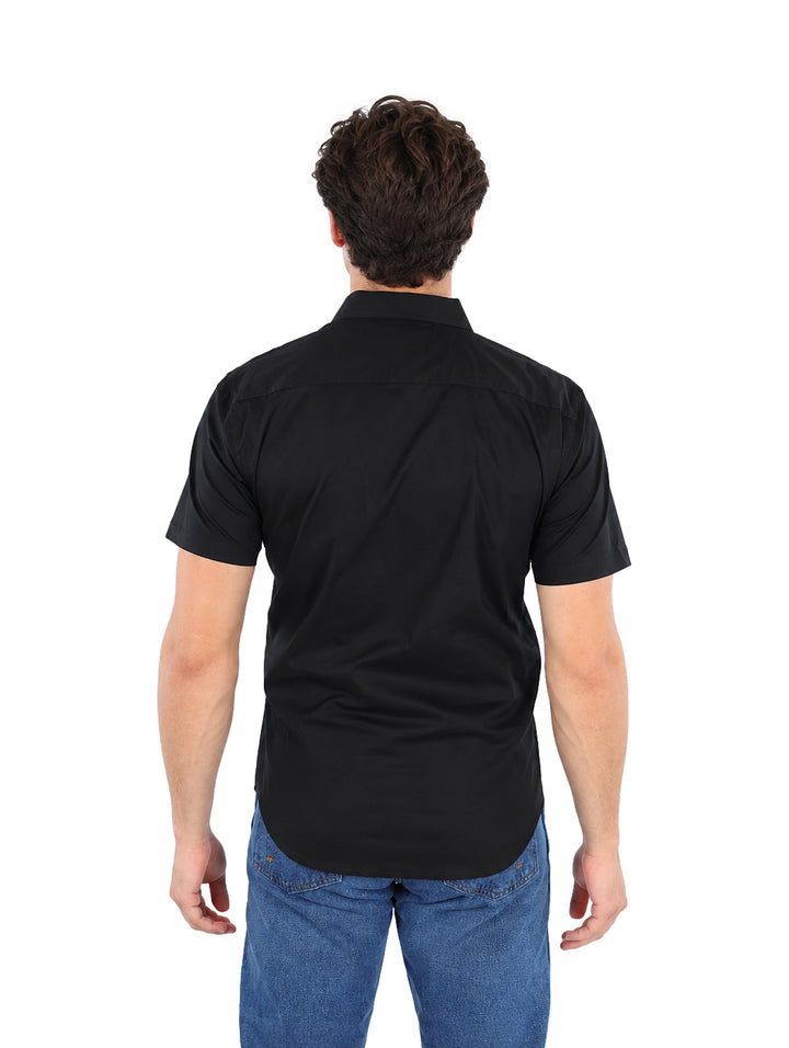 Hombre modelando una camisa negra de manga corta con botones y cuello.