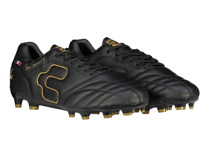 Zapato de fútbol Charly color negro con detalles y tacos en color dorado.