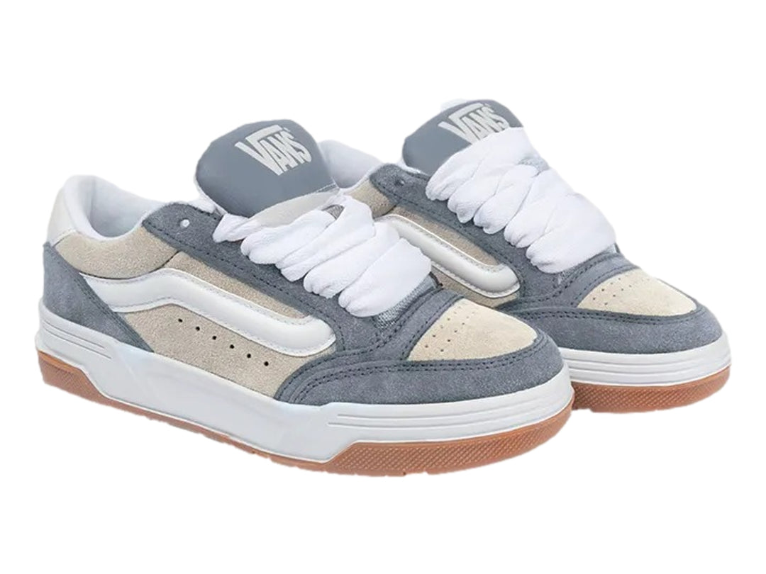 Tenis Vans color azul y crema con suela de goma marrón y cordones blancos.