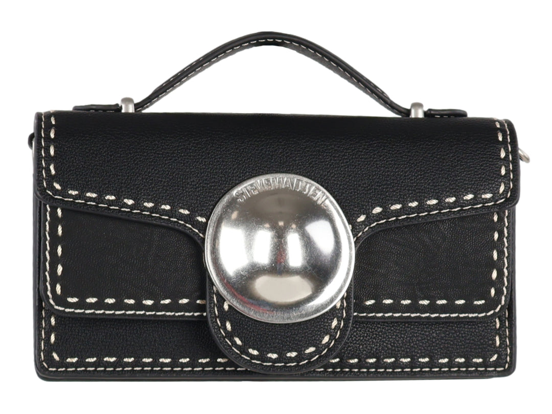 Bolso negro rectangular con costuras blancas y un adorno circular plateado central.