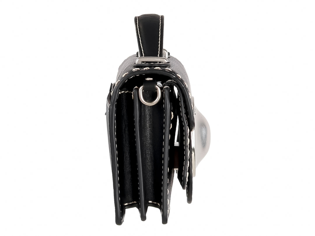 Bolso negro rectangular con costuras blancas y un adorno circular plateado central.