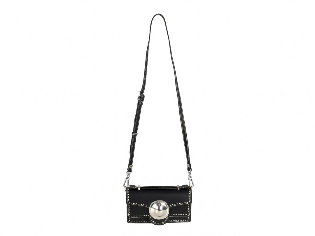 Bolso negro rectangular con costuras blancas y un adorno circular plateado central.