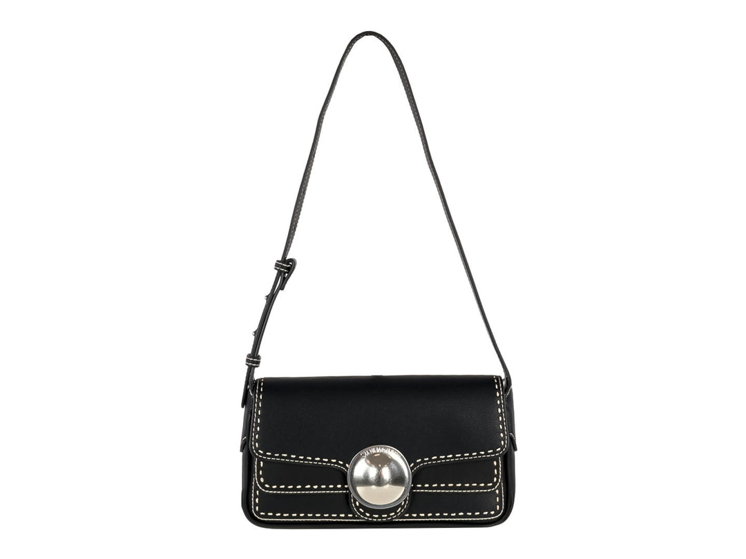 Bolsa de hombro rectangular color negro con costuras blancas y cierre circular plateado.