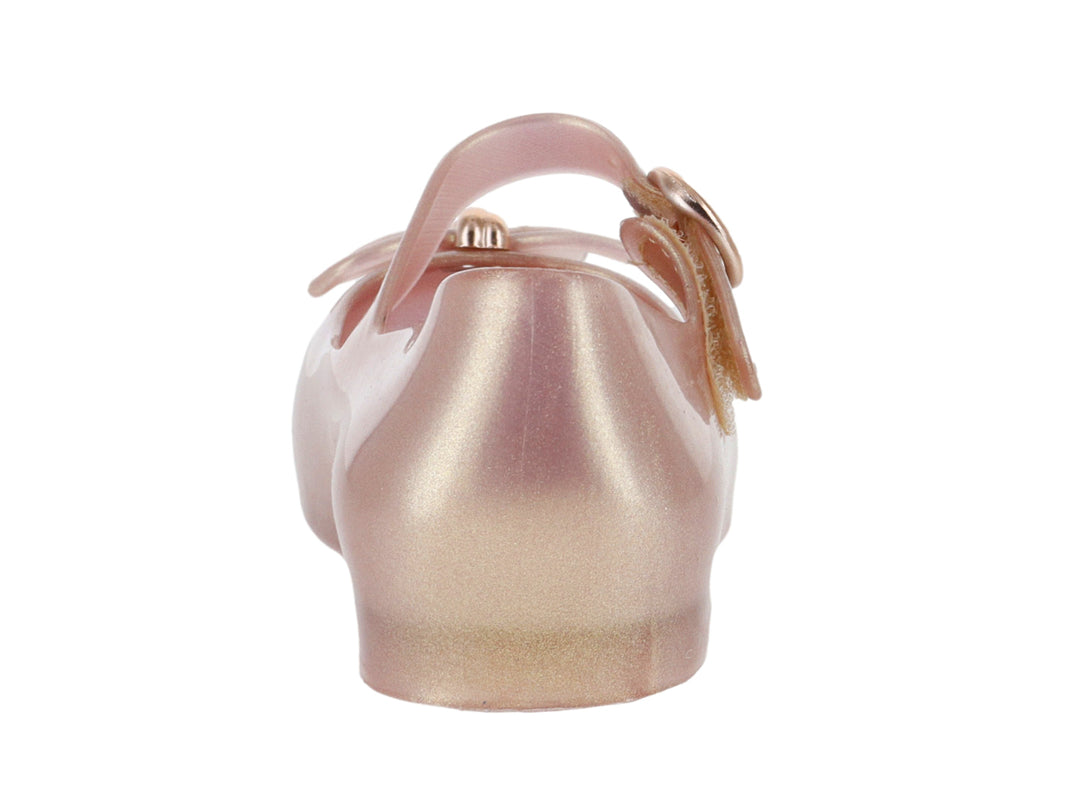 Zapato infantil Mary Jane de color rosa perlado con correa y moño decorativo.