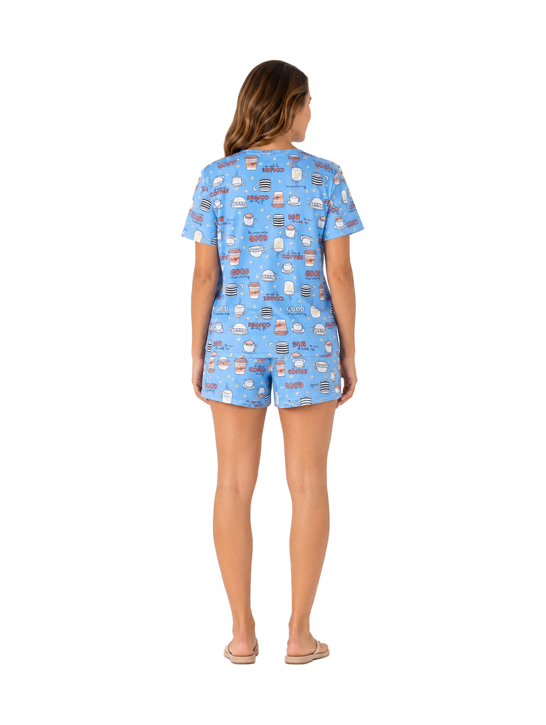 Mujer vistiendo pijama azul de dos piezas con estampado de cupcakes.
