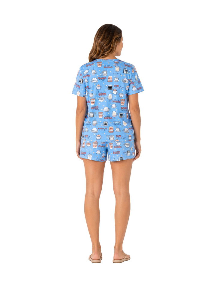 Mujer vistiendo pijama azul de dos piezas con estampado de cupcakes.