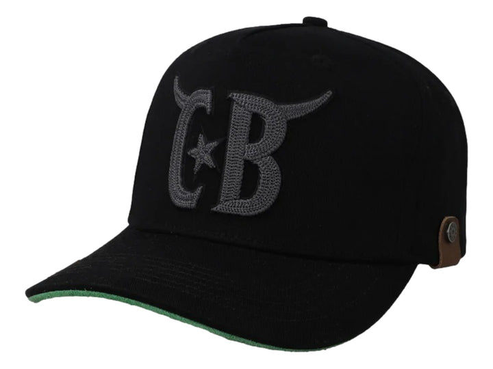 Gorra negra Cara Blanca con bordado gris de cuernos y letras CB, visera con borde verde y detalle lateral en cuero.